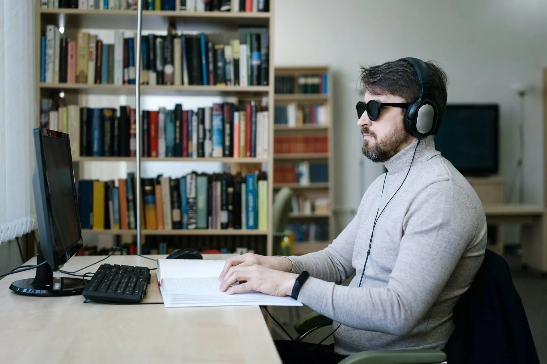 A man wearing headphones and sitting at a desk.